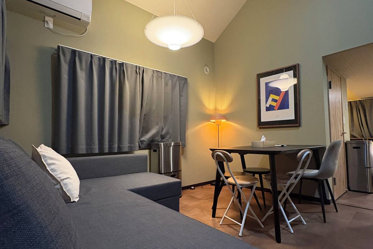 A room with a bed, a desk, a chair, a lamp, and a picture on the wall.