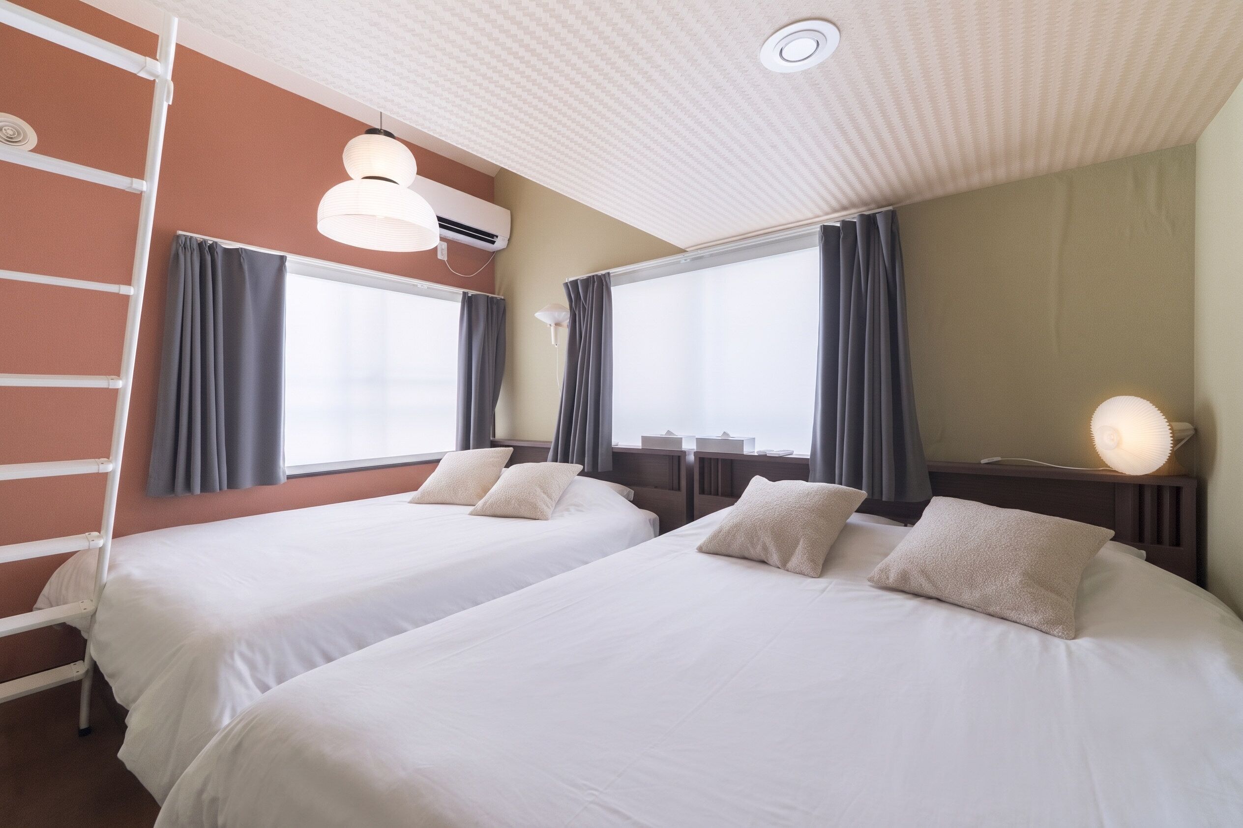 A hotel room with two beds, a ladder, an air conditioning unit, and a large window with curtains.