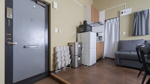 Une petite cuisine équipée d’un réfrigérateur, d’un four à micro-ondes et d’une petite machine à café.