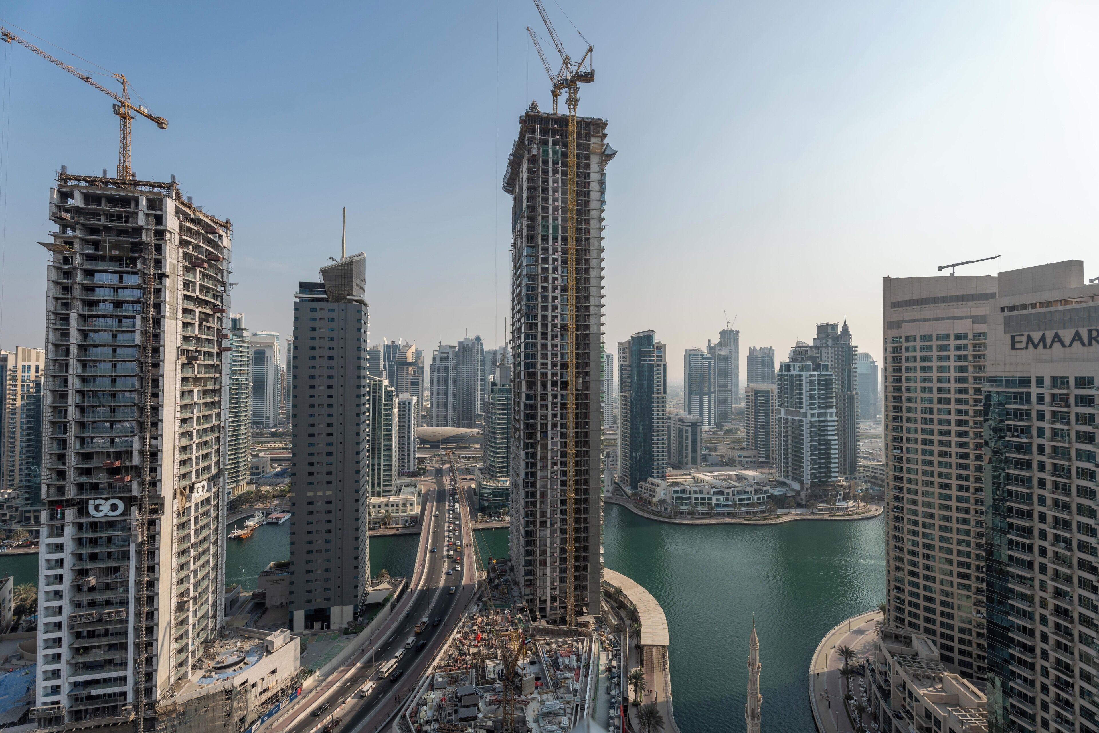 Ein Hochhaus im Bau mit Blick auf eine Marina und weitere Gebäude im Hintergrund.