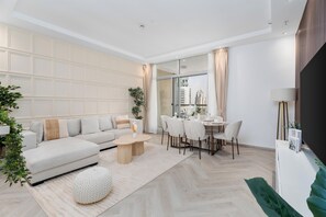 Ein modernes Wohnzimmer mit einer Couch, einem Esstisch, Stühlen und einem Couchtisch.