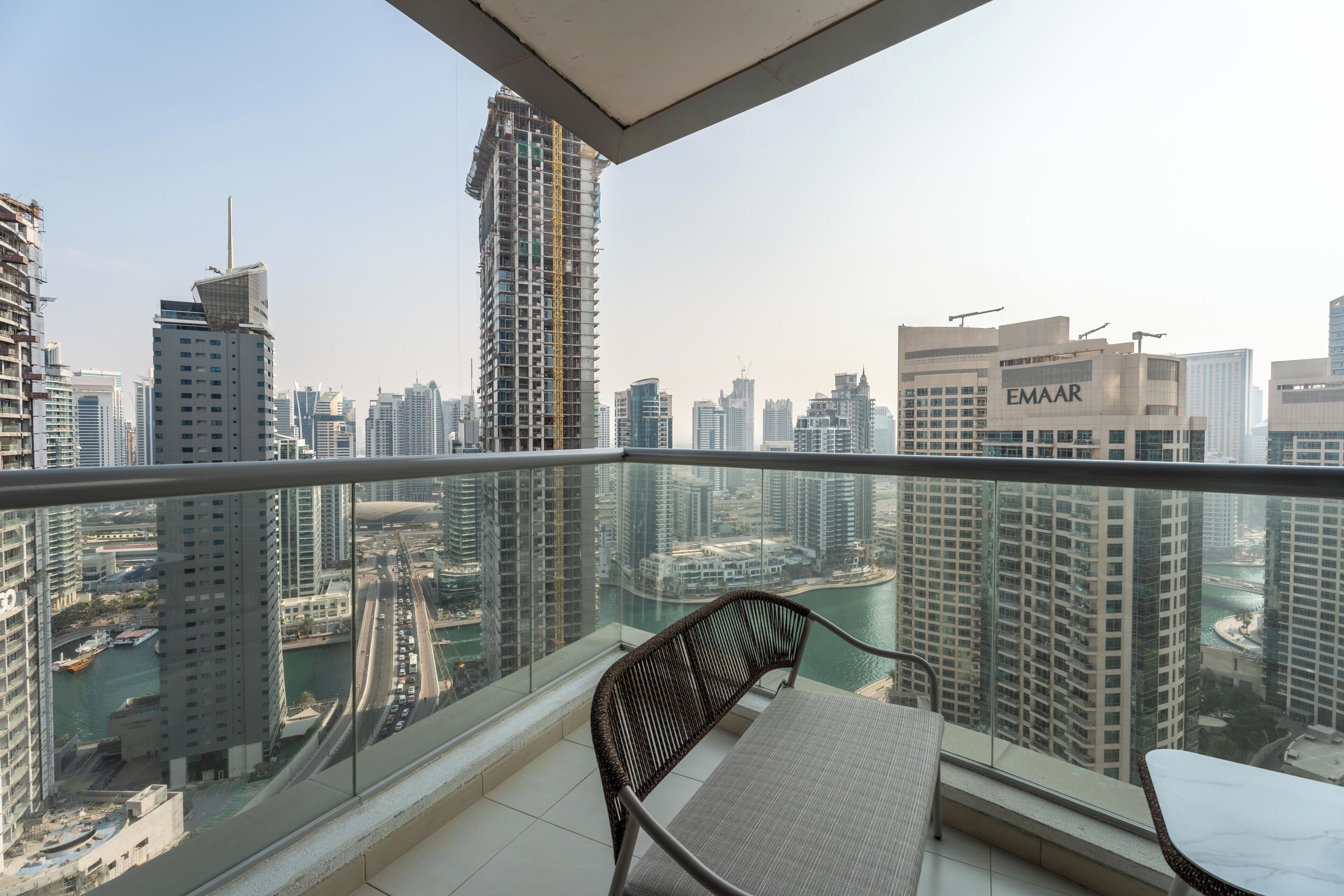A balcony with a view of a cityscape, including high-rise buildings and a marina.