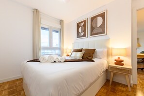 A neatly made bed with pillows, a bedside lamp, and artwork on the wall. - M (MOS34D7E) Spacious and elegant two-bedroom apartment with terrace (Madrid)