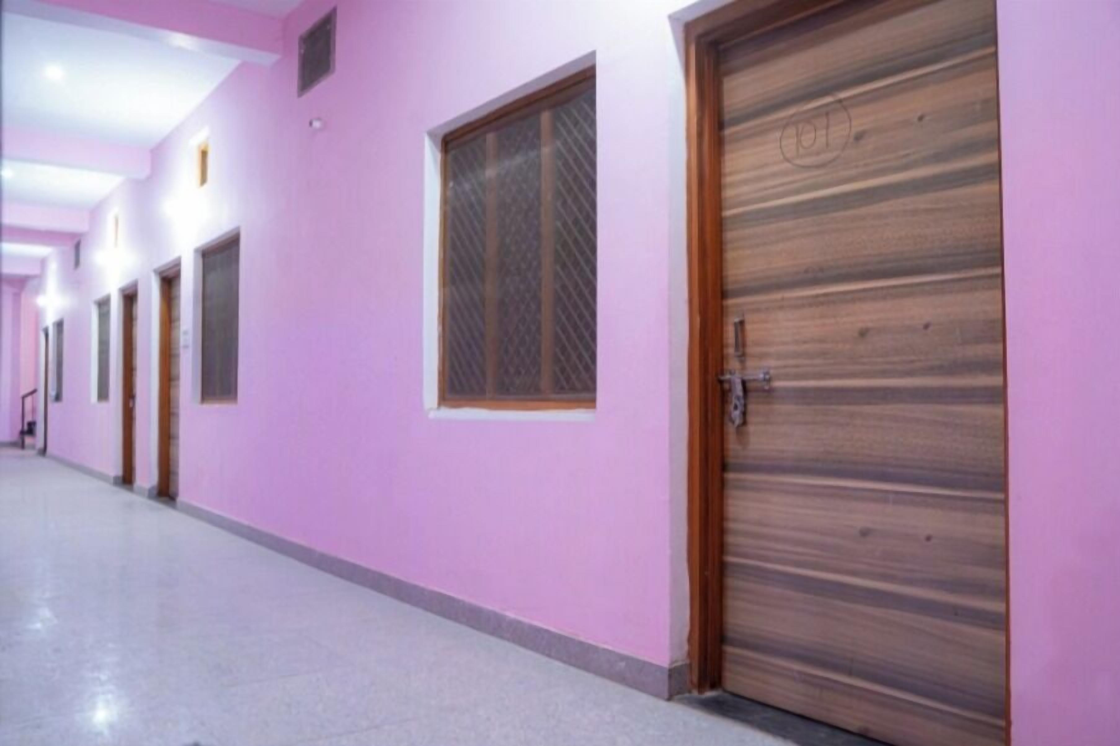 A hallway with pink walls and wooden doors.