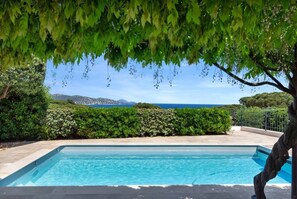 Ein Swimmingpool mit Blick auf das Meer und die Berge.