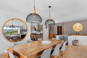 Eine moderne Küche mit Blick, ein Essbereich mit Holztisch und ein 'WELCOME'-Schild.