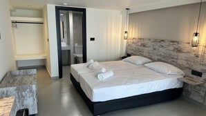 A modern hotel room with a large bed, a walk-in closet, and a bathroom. - Evita Flamingo (Kos)