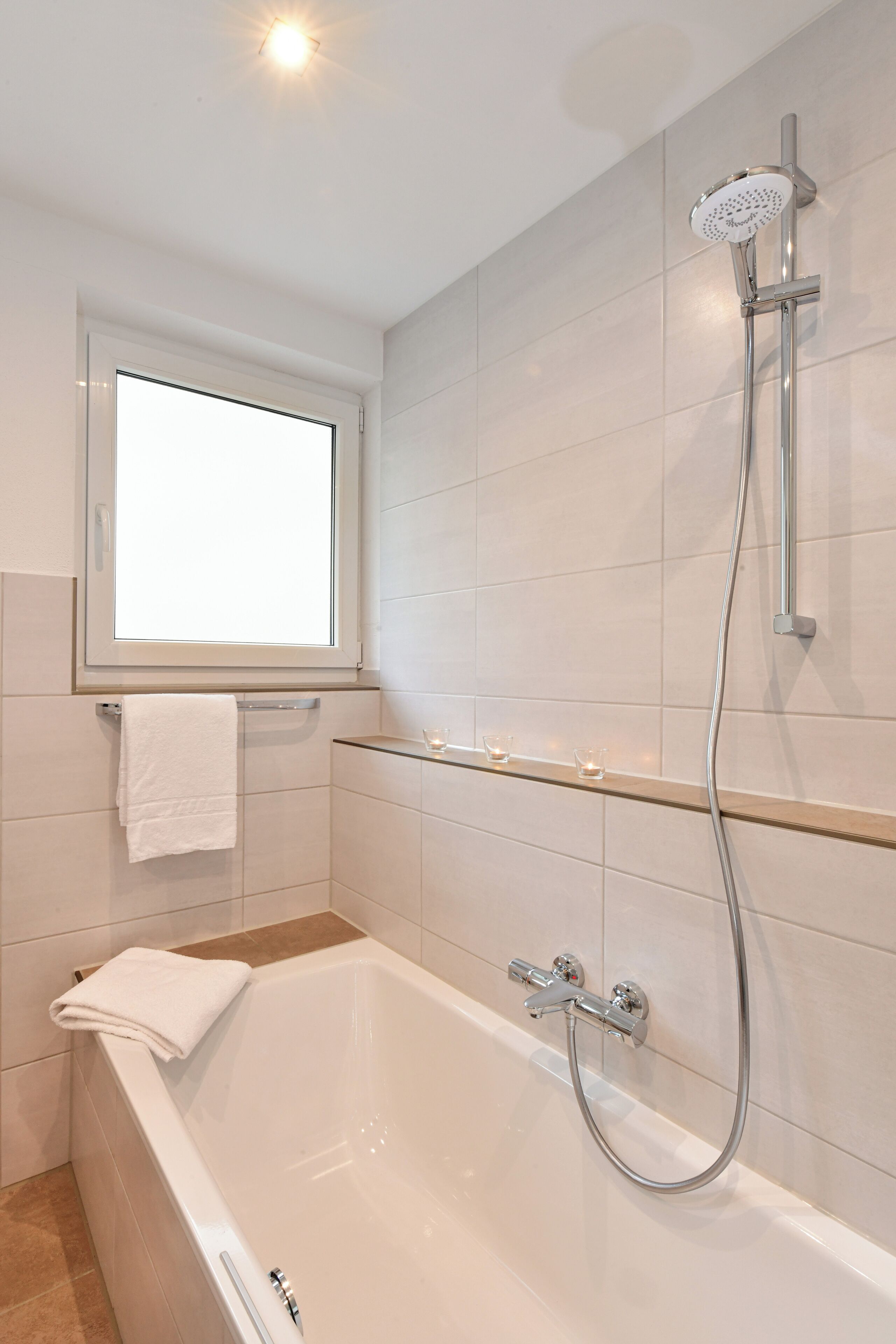 Un baño moderno con bañera, ducha y ventana.