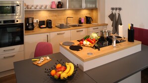 Una cocina moderna con encimera de madera, electrodomésticos de acero inoxidable y un frutero.