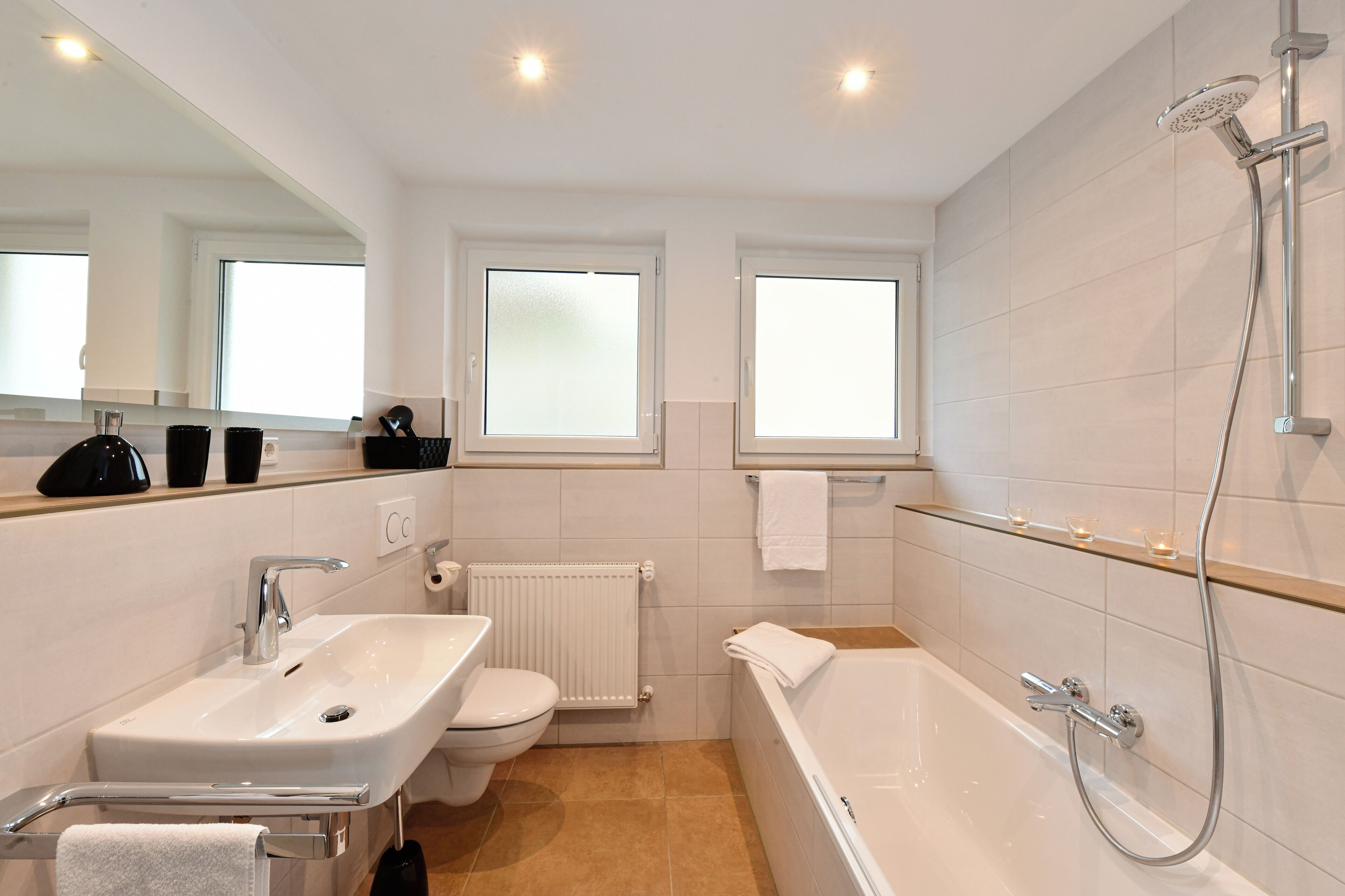 Un baño moderno con lavamanos, inodoro, bañera y ducha.