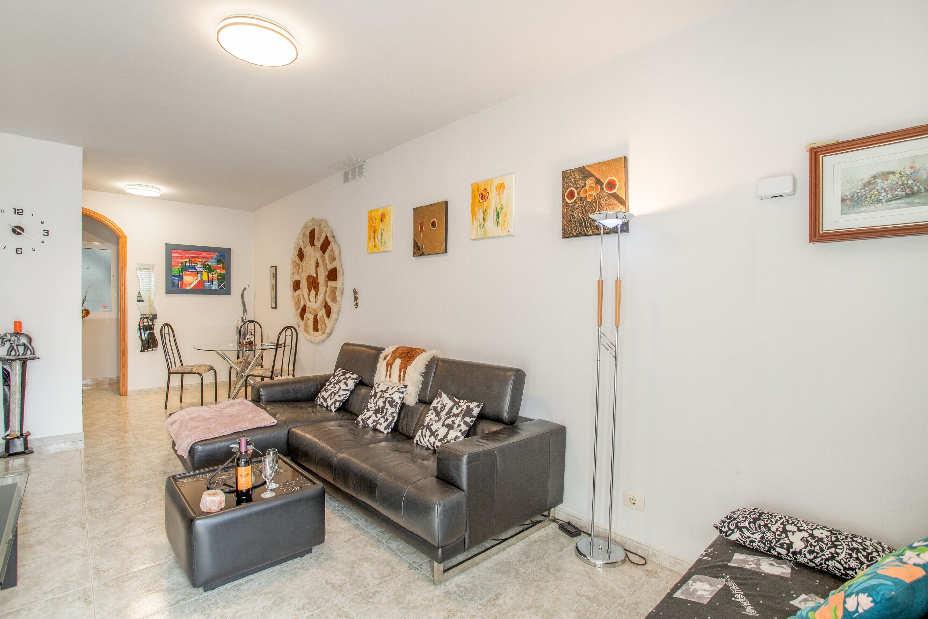 Una sala de estar moderna con sofá, mesa de centro y obras de arte en las paredes.