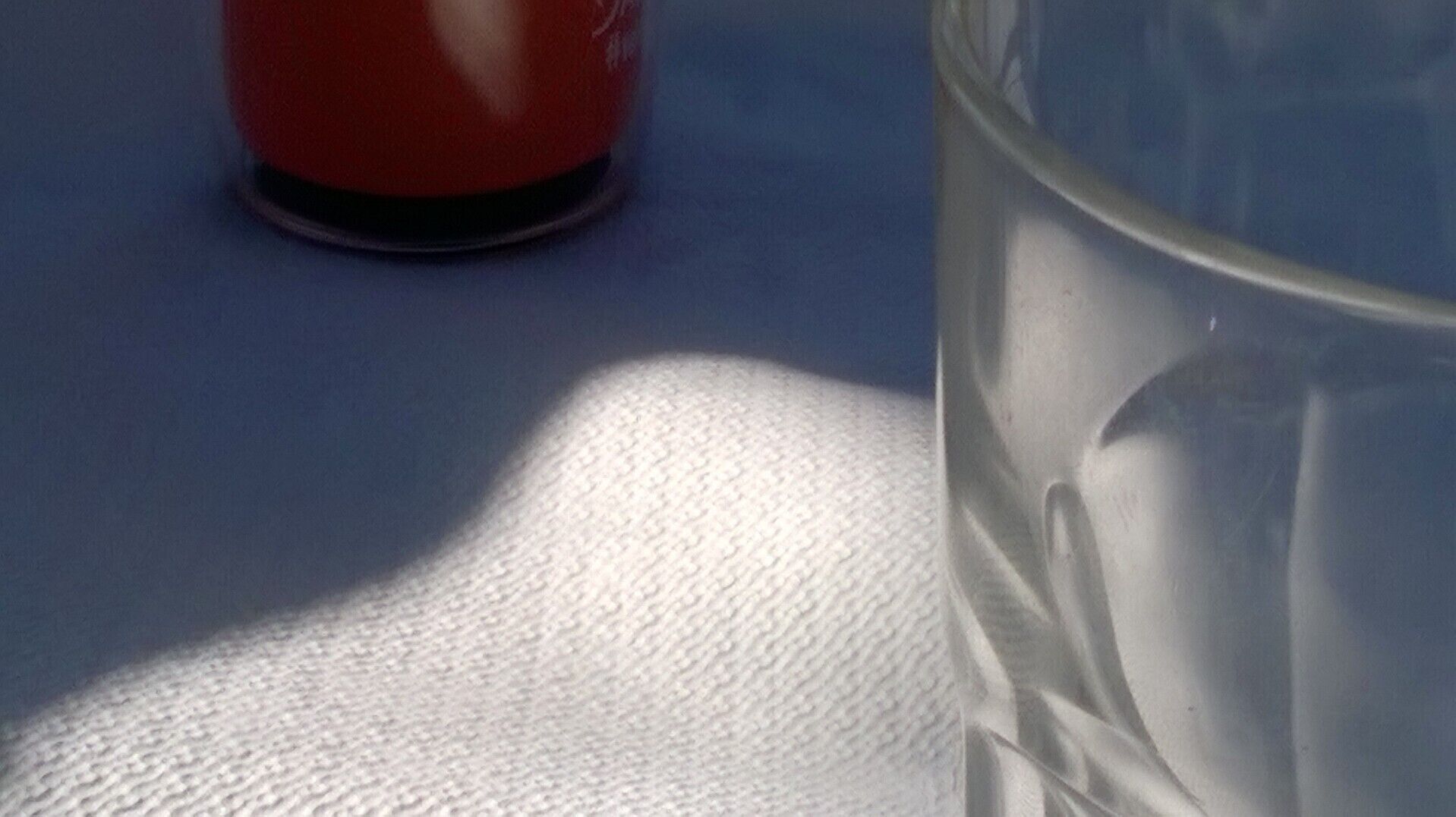 Ein Glas Wasser auf einer weißen Fläche.