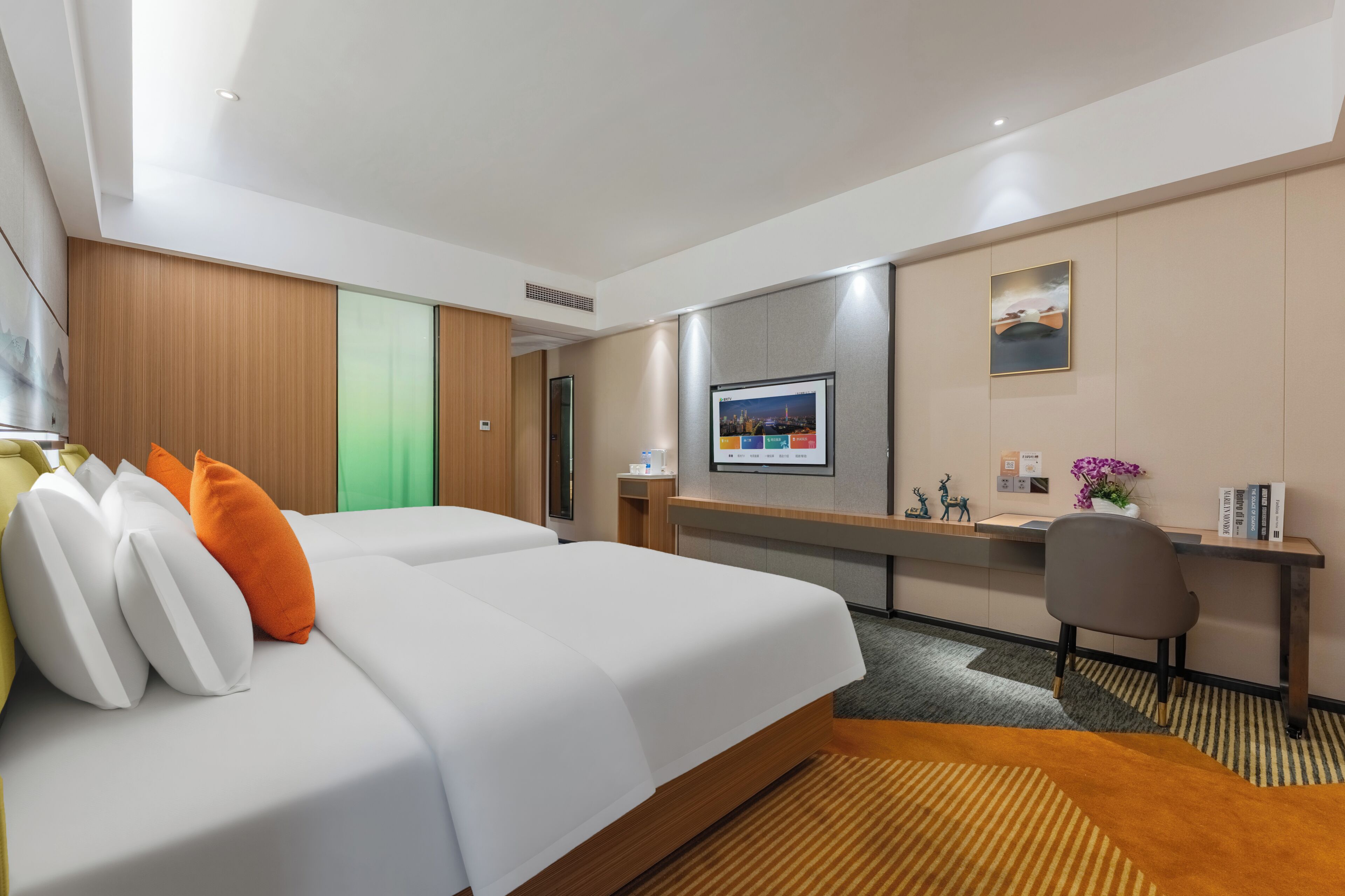 A hotel room with a bed, desk, and television.