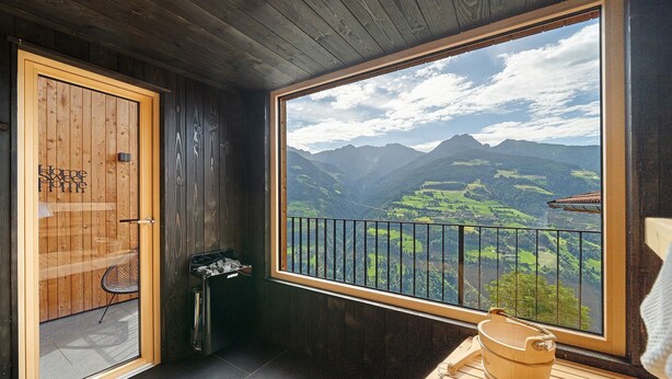 Un intérieur en bois avec une grande fenêtre donnant sur un paysage montagneux.