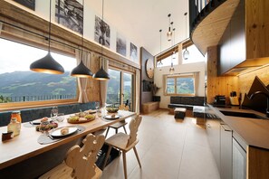Una cocina moderna con comedor, ventanas amplias y vistas a la montaña.