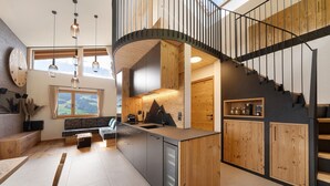 Une cuisine moderne dotée d’un îlot central, de meubles en bois et d’un escalier en colimaçon.