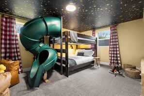 A bunk bed with a green slide, checkered curtains, and a star-patterned ceiling. - The Boise Rec Retreat-theater, pool table, arcade (Boise)