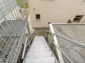 A metal staircase with a handrail leading to a building with a beige exterior. - The Nest (Glastonbury)
