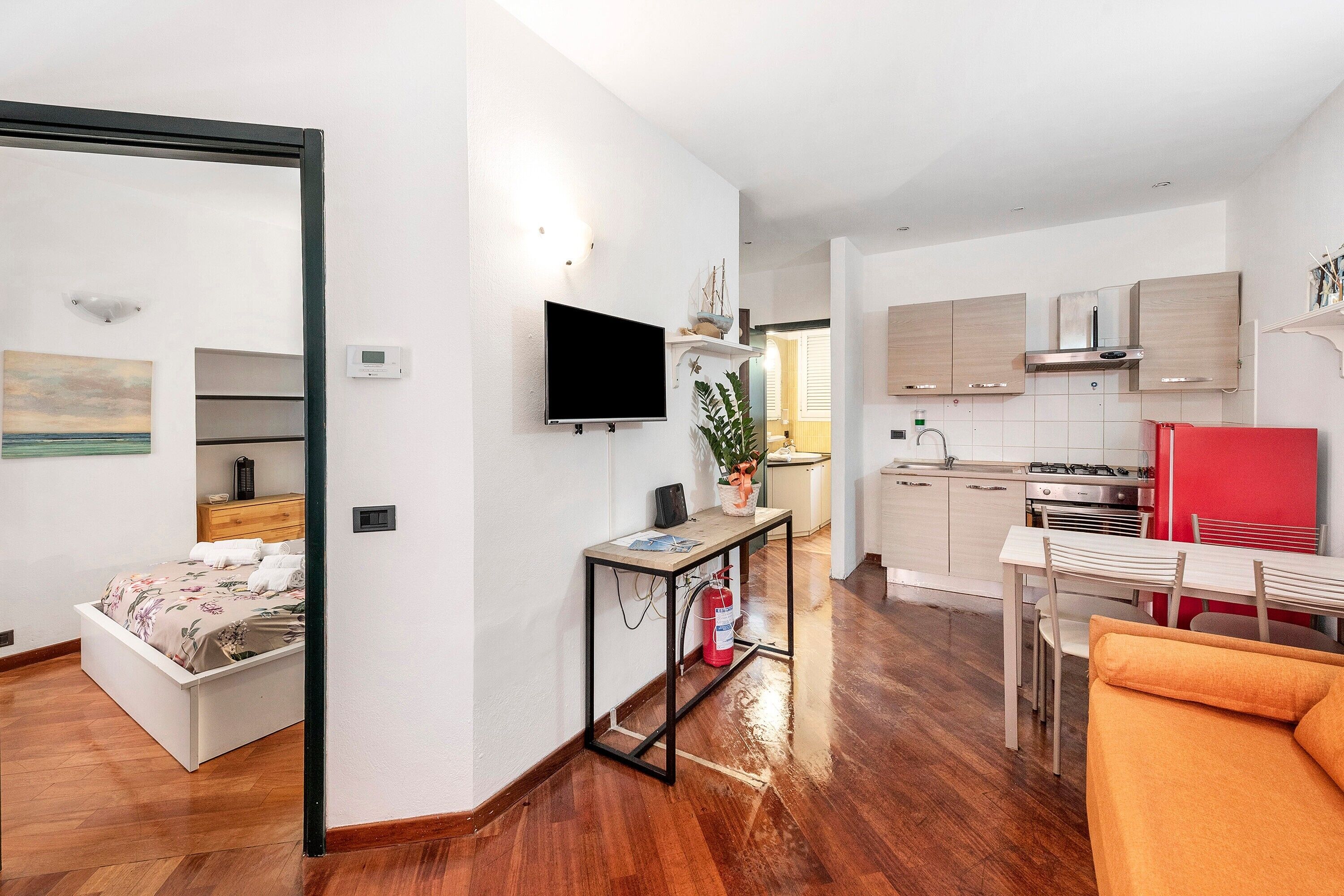 A modern apartment with a bed, a dining area, and a kitchen.