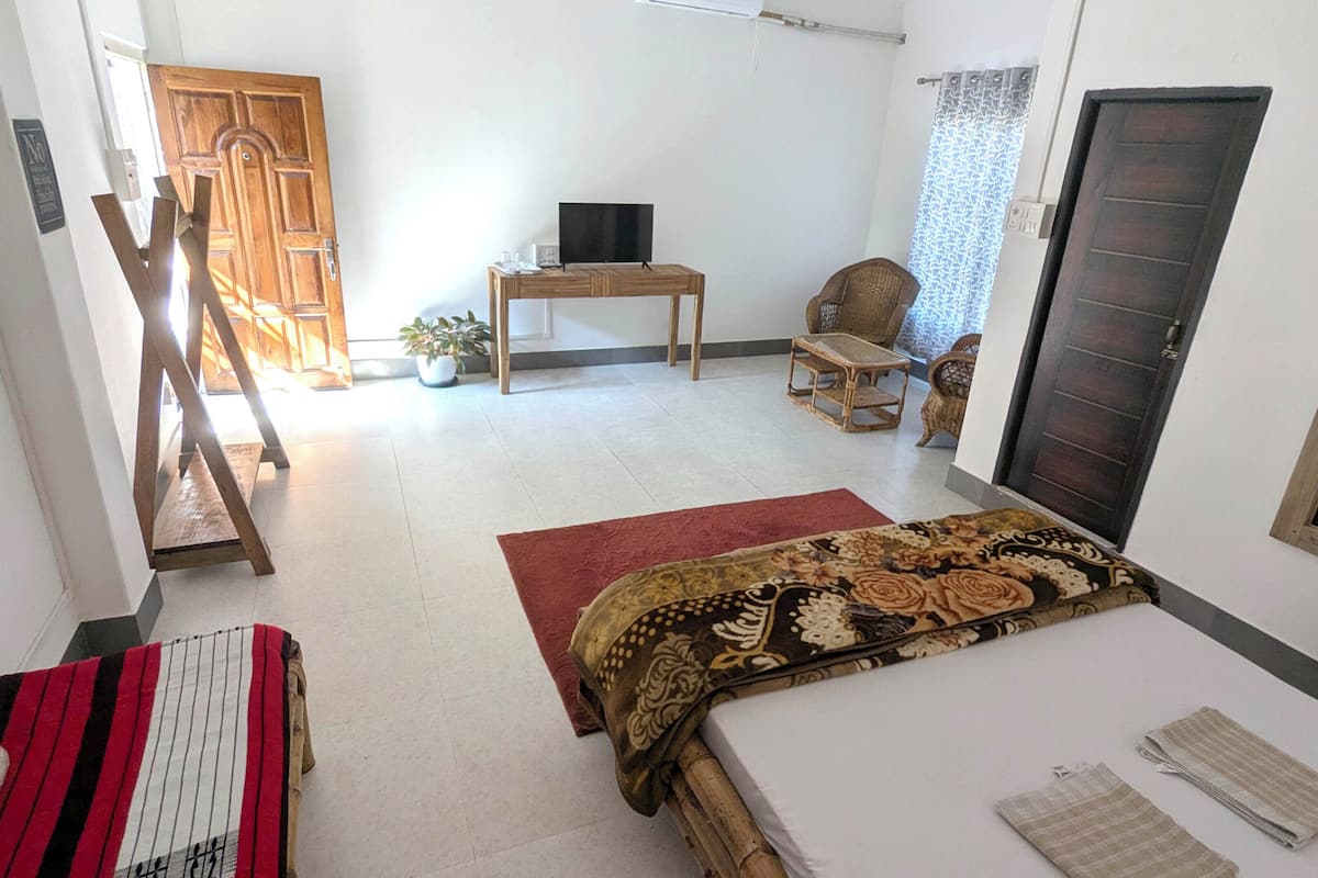 A room with a bed, a desk, a chair, a television, and a wardrobe.