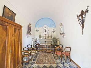 A chapel with a tiled floor, wooden chairs, a central altar, and religious statues. - Maison de Famille du XIX° siècle - Property in Terre de PROVENCE- swimming pool (Saint-Chamas)