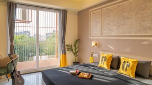 A bedroom with a bed, a guitar, a plant, and a view of the outdoors. - The Hosteller Gurgaon (Gurugram)