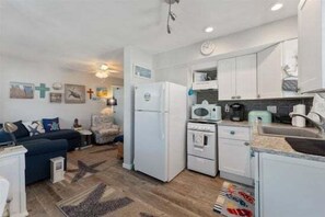 A compact living space with a kitchenette, a sofa, a coffee table, and a ceiling fan. - 5600 Seaview Ave, Unit 34 (Wildwood Crest)