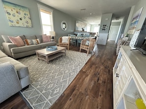 A living room with a sofa, coffee table, and patterned rug.