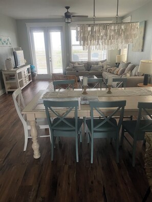 A dining area with a table, chairs, and a ceiling fan.