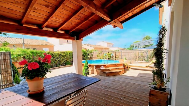 An outdoor patio with a wooden table and chairs, a pool, and a wooden deck. - House in the heart of the Alpilles (Maussane-les-Alpilles)