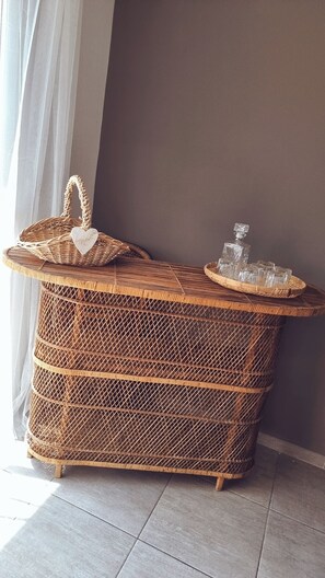 A wicker bar with a tray of glasses and a bottle, positioned against a wall with a curtain. - House in the heart of the Alpilles (Maussane-les-Alpilles)