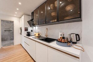 A modern kitchen with a black sink, a yellow toaster, and a coffee maker. - Lit Living Worms (Worms)
