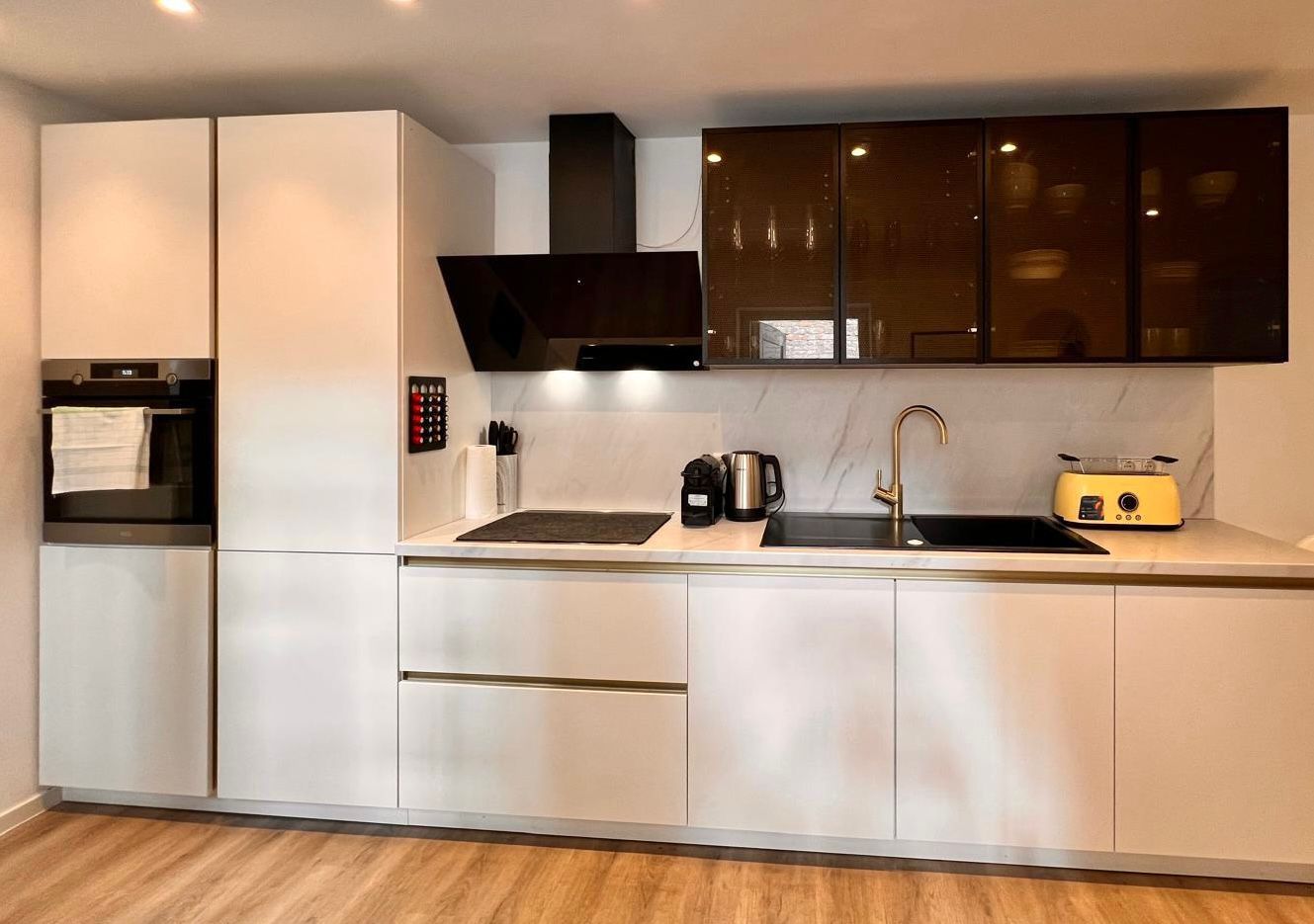 Eine moderne Küche mit Backofen, Spüle und Toaster.
