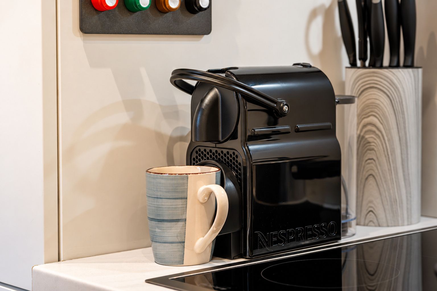 Une machine à café dotée d’un panneau de commande et d’une tasse posée sur un comptoir.