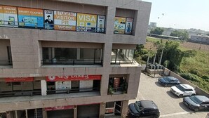 A multi-story building with various signs, including 'STUDENT VISITOR VISA PR WORK' and 'SHREEET CLINIC.'