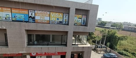 Un edificio de varios pisos con varios letreros, incluyendo 'STUDENT VISITOR VISA PR WORK' y 'SHREEET CLINIC'.