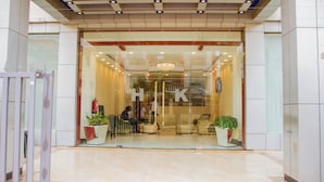 A hotel entrance with a glass facade, a reception desk, and potted plants. - Hotel Kilimanjaro (Luanda)