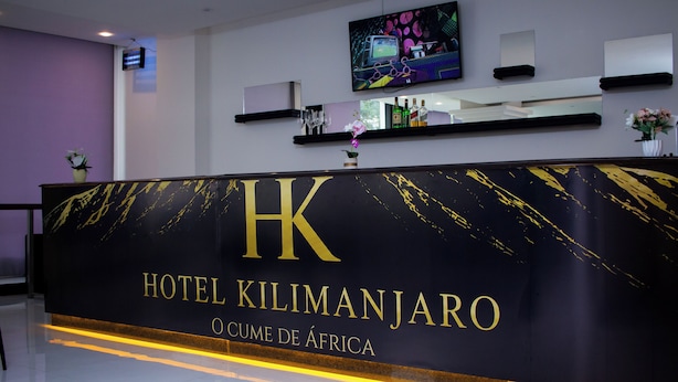 A reception desk with the sign 'HOTEL KILIMANJARO O CUME DE AFRICA' and a television mounted above it. - Hotel Kilimanjaro (Luanda)