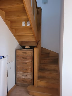 Eine Holztreppe mit einem Heizkörper und einer Holzkommode.