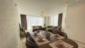 Un comedor moderno con una mesa larga dispuesta para cuatro personas, rodeada de asientos cómodos.