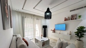 Ein modernes Wohnzimmer mit einer Couch, einem Couchtisch, einem Fernseher und Wanddekoration.
