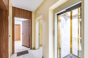 A hallway with wooden doors, a marble floor, and a glass door with a gold frame. - Apartment in the center of Marrakech 5 minutes from the Casino de Marrakech. (Marrakech)