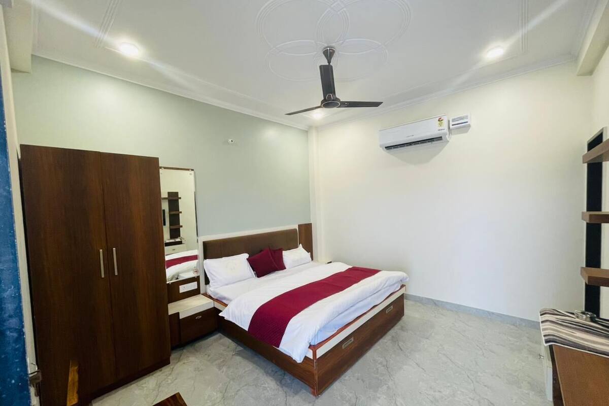 Un dormitorio con cama, armario, mesita de noche y ventilador de techo.