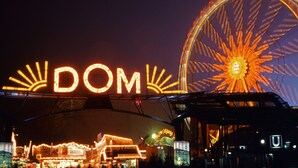 A night scene with a large illuminated sign reading 'DOM' and a prominent Ferris wheel. - Urban & close to nature at Alter Bahnhof near Hamburg Bright apartment with 3 bedrooms (Trittau)