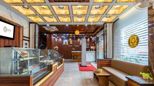 Un hall d’hôtel comprenant un comptoir d’accueil, un espace salon et une vitrine.