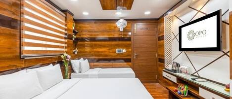 Una habitación de hotel con una cama, un televisor, una pared de madera y un armario de madera.