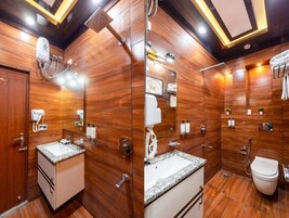Un baño moderno con paredes de madera, un lavabo, un inodoro y una ducha.
