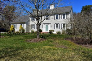 A two-story house with a green door, white siding, and a well-maintained lawn. - Modern upscale 5 bedroom home, close to Mayflower Beach! (Dennis)