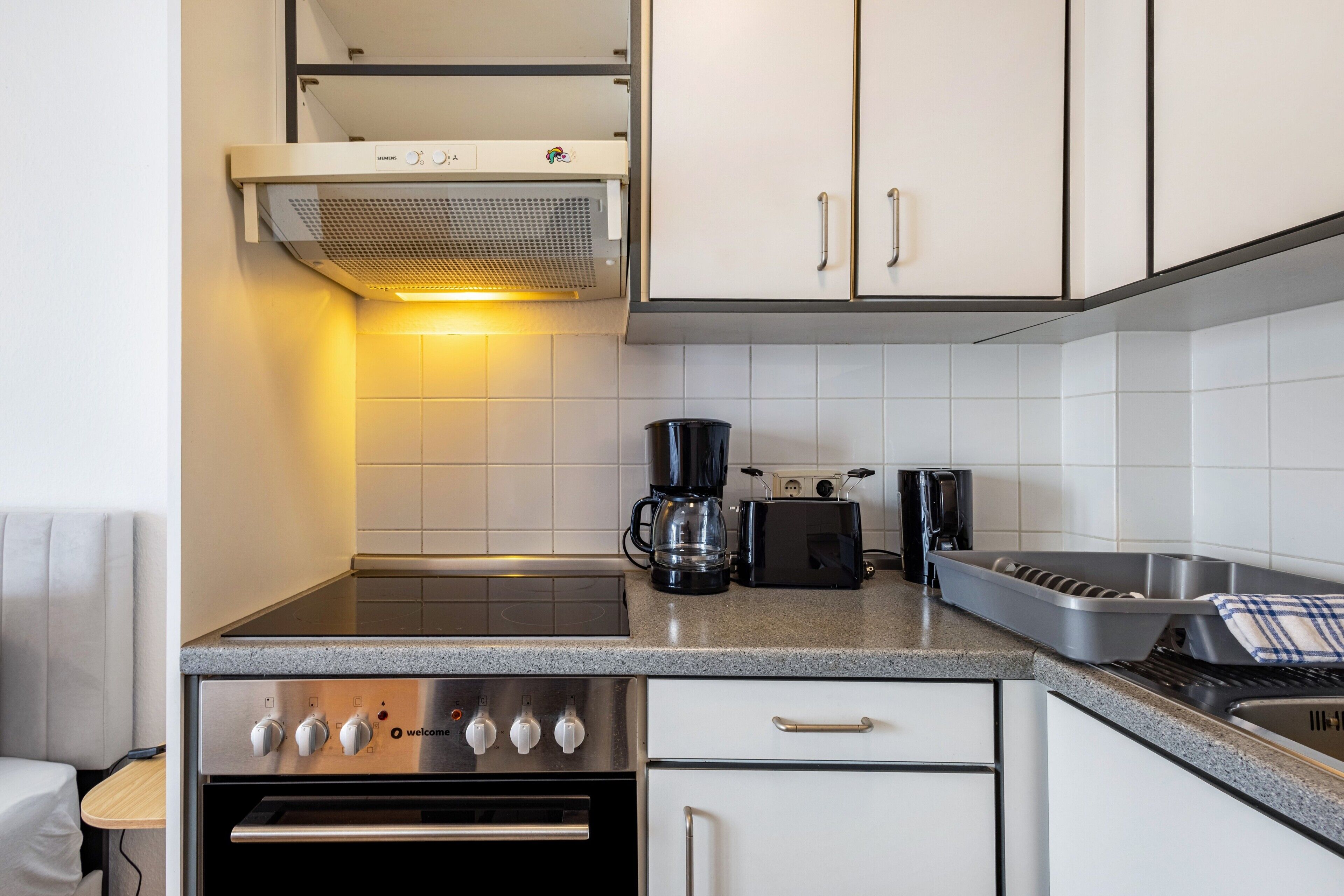 A modern kitchen with a built-in oven, a coffee maker, and a toaster.