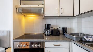 A modern kitchen with a built-in oven, a coffee maker, and a toaster.
